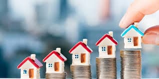 Huisjes op stijgende stapels munten — woningwaarde berekenen in 2026